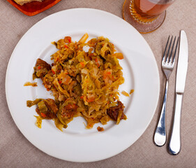 Delicious meat dish - pork with stewed cabbage served on plate. High quality photo