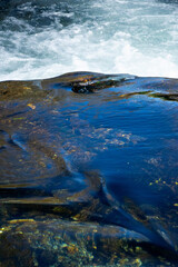 Klarer Gebirgsfluss über Felsen mit blauem Wasser – Frische und Bewegung