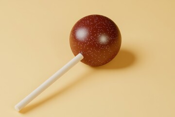A single chocolate lollipop resting on a cream colored surface
