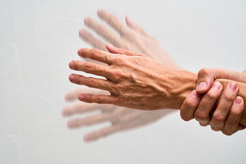 Trembling hand holding glass concept parkinson.