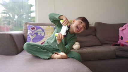 A joyful young girl plays video games with excitement, moving energetically as she enjoys the game. Her face lights up with happiness and focus in a fun, immersive gaming experience at home.
