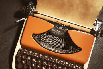 Old vintage typewriter with paper on grey table, top view