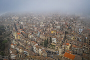 Obraz premium Sunrise view of the rooftops of Gangi with morning fog. Sicily, Italy. August 2024. Aerial drone picture.