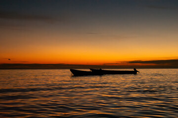 Naklejka premium Serene Sunset Over Rincón del Mar with Silhouetted Boats on the Caribbean Sea