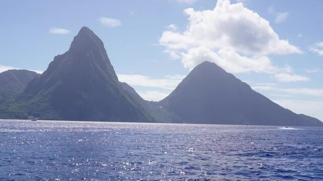 Ocean view of the iconic Twin Pitons, rising sharply from the sea under a patterned sky in Saint Lucia.