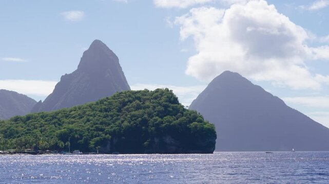 Ocean view of the iconic Twin Pitons, rising sharply from the sea under a patterned sky in Saint Lucia.