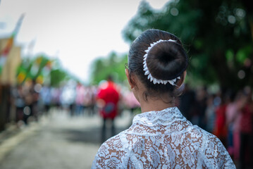 A woman's hair bun with a white ribbon
