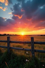 Fototapeta premium Vibrant summer sunset paints the sky above a weathered wooden fence in a European field , twilight, light, weathered