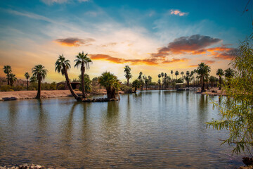 A gorgeous landscape at Papago Park with a lake, lush green palm trees and rocks in Phoenix Arizona USA
