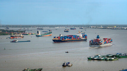 Obraz premium Cargo ship transporting containers on Saigon River from port to East Sea