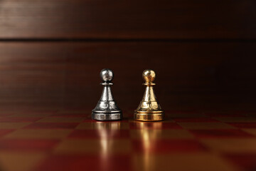 Golden and silver pawns in middle of chessboard. Competition concept