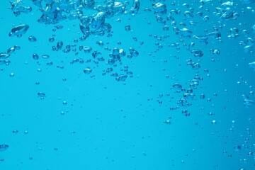 Many water bubbles on blue background, closeup