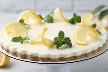 Delicious lemon cheesecake with mint on white table, closeup