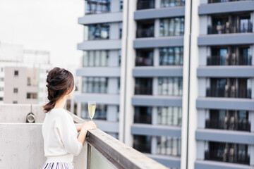 ペントハウスでワインを愉しむリッチな女性