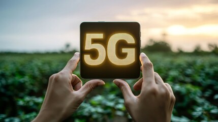 Hands Holding Digital Display Showing 5G Technology in Agricultural Field During Sunset with Green Plants in Background