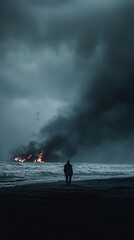 Silhouette of a Man Watching a Burning Structure on a Dark Stormy Beach