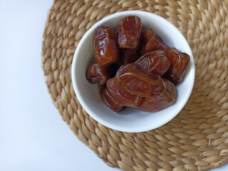 Dried dates in a white bowl. Dates have a sweet taste and are popular during the month of Ramadan