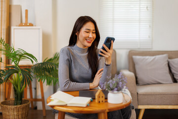 Beautiful asian businesswoman or female executive manager sits at her worktable and uses a smartphone.
