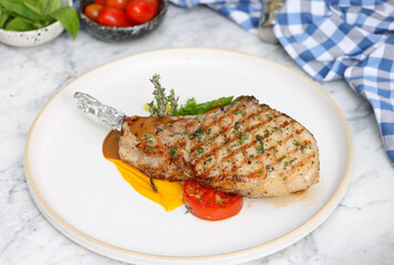 Grilled pork chop dish gourmet kitchen food photography elegant setting close-up culinary art