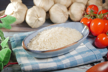 Fresh ingredients with rice and tomatoes on a wooden table