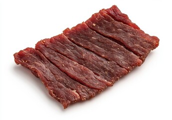 Close up of dark red beef jerky strips on a white background. The jerky is arranged neatly and appears to be seasoned. High angle shot