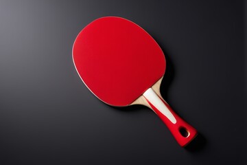 a close up of a red ping pong paddle on a black surface
