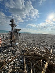 Fototapeta premium Enjoying a sunny day by the beach while preparing a traditional tea with a samovar