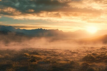 Fototapeta premium A beautiful sunset illuminating mountains and a hazy grassy landscape