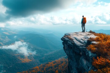 Hiker standing on a cliff enjoying the autumn mountain landscape