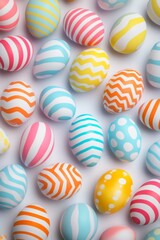Obraz premium Colorful Easter eggs, decorated with stripes, polka dots, and patterns, arranged on white background