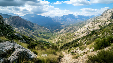 Obraz premium view of a mountain nature trail with rugged rocks and a wide valley below, showing the vastness of the natural landscape 