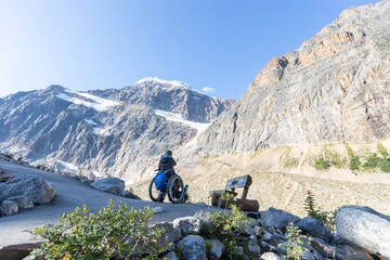Wheelchair Adventurer Enjoying Breathtaking Mountain View on Accessible Hiking Trail in Jasper...