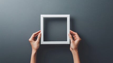 Holding square frame on grey background. Simple presentation. Empty space for creative design