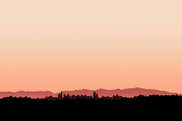 Silhouette of City Skyline Against Soft Sunrise Horizon