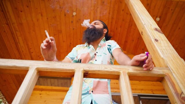 Pensive guy with cigarette at balcony deep in thought