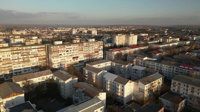 Flying over Botosani, Romania. Residential area with tall apartment buildings lit up by the dim twilight