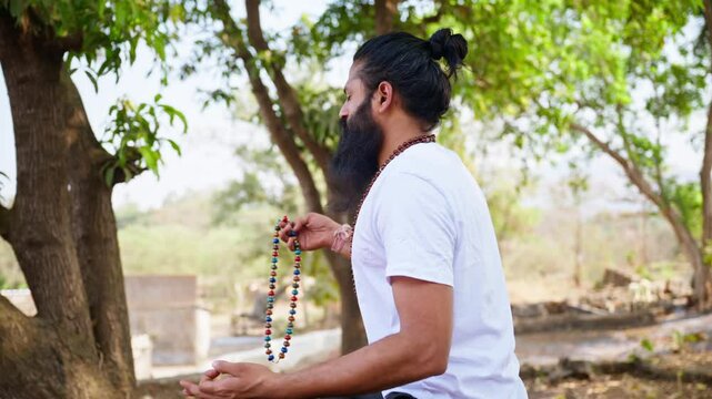 Bearded man meditates beneath trees at retreat