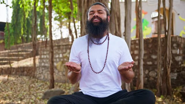 Bearded spiritual man lifted hands praying at retreat