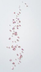 A scattering of shimmering scales rests on an elegant pearl white background with subtle texture and shimmering effect, oceanic, serene