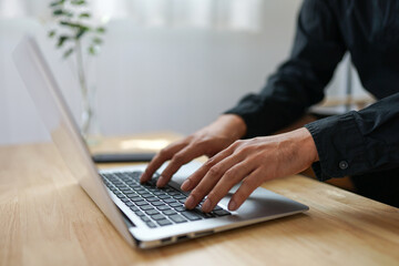 Close up view male hands writes on laptop. Entrepreneur man sit at desk work on modern wireless notebook, do remote telecommute, search information on internet, professional application usage concept
