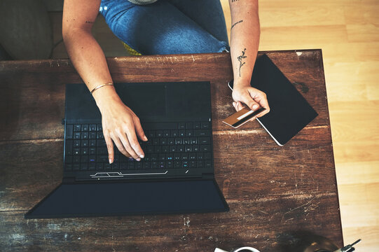 Person, hands and laptop with credit card above for online banking, payment or shopping at home. Top view, shopper or customer with computer or debit for wireless transaction or remote purchase