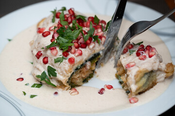 chile en nogada partido con vista del relleno y adornado con granada 