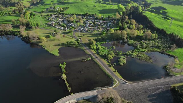 Aerial view of Whakamaru Dam in New Zealand, showcasing a serene lake, surrounding lush greenery, and the harmonious blend of nature with infrastructure. Sustainable water management.