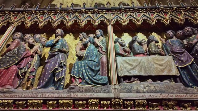 Detailed religious stone carvings inside the historic Notre Dame cathedral wall depicting biblical scenes, Paris, France.