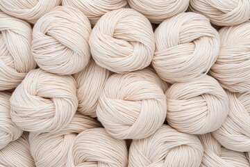 Soft cream colored yarn balls arranged in textured pattern, perfect for knitting and crafting projects. smooth fibers create cozy and inviting look