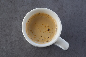 淹れたてのコーヒーが入ったマグカップを、真上から俯瞰した画像
