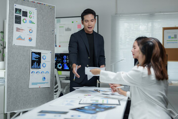 Naklejka premium Marketing team discussing new project and sharing documents with charts and statistics