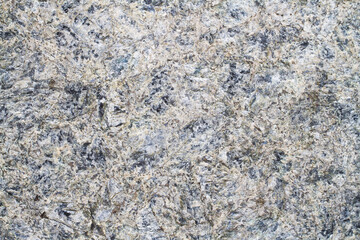 The texture of natural unpolished granite. The rock is made of natural stone.