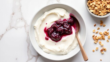 Yogurt with berry sauce and granola on marble surface