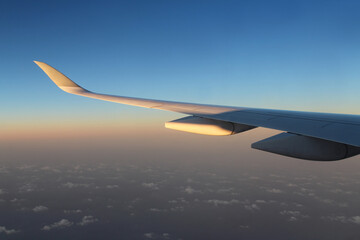Dramatic cloudscape and landscape during sunrise from the airplane's window